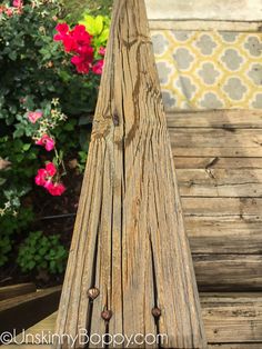 an old wooden fence with flowers in the background