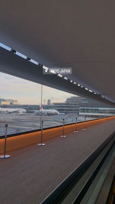 there is a sign that says tokyo japan on the side of an airport terminal roof