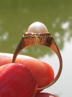 "This is another lovely fine ring! This is marked 14K on the inner band, and it also has a triangle maker hallmark I cannot identify. The pearl and the mount of the ring measures 3/8\". The band is thinner off to the side of the mount, with it getting wider at the back, which is more unusual. The mount is is open cut, really lovely, with a nice white pearl. This ring rests exactly between a 5 & 1/2 and 5 & 3/4 on a mandrel. The total weight is 3.5 grams. Nice!" Parents Anniversary, Fine Ring, White Band, White Pearl, Gold Style, Solitaire Ring, Pearl White, Women Rings, Hallmark