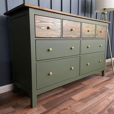 a green dresser sitting on top of a hard wood floor next to a blue wall