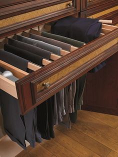 an open drawer with clothes hanging on it