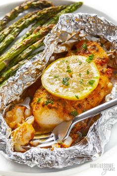 chicken and asparagus wrapped in foil on a plate