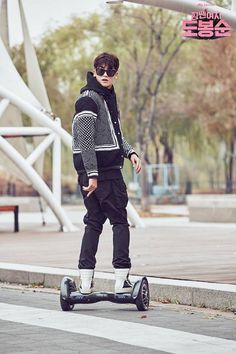 a young man riding an electric scooter on the street