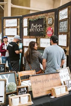 several people standing around a table with signs on it and coffee cups in front of them