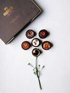 chocolates are arranged on top of each other in front of a box and flower