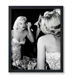 a black and white photo of a woman brushing her teeth in front of a mirror