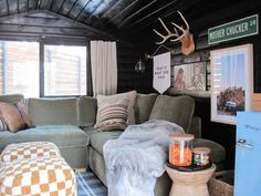 a living room filled with furniture next to a window covered in deer antlers'head