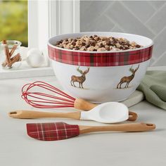 a bowl filled with cereal next to two wooden spoons