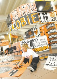 a woman sitting on the floor in front of some signs