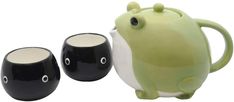 two black and white mugs sitting next to each other, one with a green frog on it