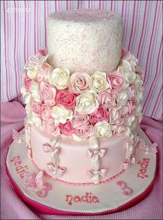 a three tiered cake decorated with pink and white flowers