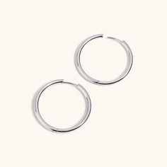 pair of silver hoop earrings on white background with clipping for use in jewelry packaging