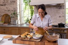 a woman is preparing food on a cutting board in the middle of a counter top