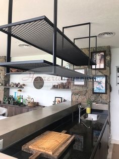 an industrial style kitchen with black counter tops and stainless steel shelving above the stove