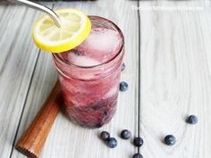 a drink with blueberries and lemon on the side