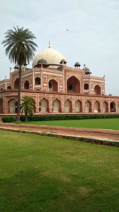 a large building with a white dome on top and palm trees in the foreground