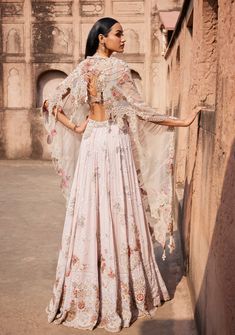 Presenting an off-white Chikankari mukaish lehenga adorned with pearl and zardozi hand embroidery. Paired seamlessly with a sheeted crystal bustier choli and an organza cutwork border-embroidered dupatta. This ensemble exudes timeless elegance, combining traditional craftsmanship with modern flair. Anarkali Style Hand Embellished Maxi Lehenga, Intricate Embroidered Georgette Lehenga Maxi, Georgette Lehenga With Intricate Embroidery, Anarkali Set With Sheer Dupatta And Cape Sleeves, Intricate Embroidery Georgette Lehenga Maxi Length, Anarkali Lehenga With Pearl Embroidery, Anarkali Sets With Pearl Embroidery And Traditional Drape, Intricate Embroidery Georgette Lehenga, Semi-stitched Floor-length Anarkali Set With Pearl Embroidery