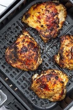 four pieces of chicken cooking in an air fryer