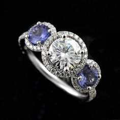 three stone diamond and tanzanite ring with blue sapphires in white gold setting