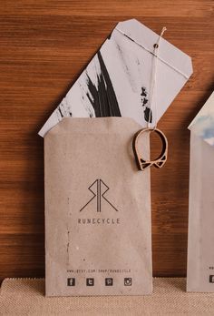 two brown paper bags sitting on top of a wooden table