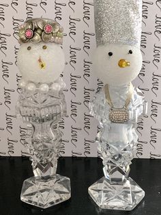 two glass figurines with snowmen on them