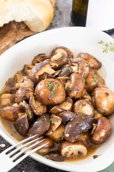 a white bowl filled with mushrooms on top of a table