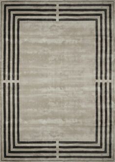 an area rug with black and white stripes on the border, in front of a gray background