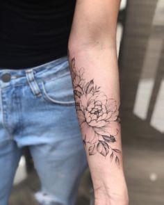 a woman's arm with a flower tattoo on the left side of her arm