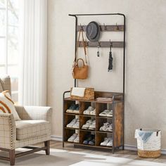 a living room filled with furniture and a coat rack on the wall next to a window