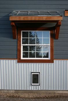 a small window on the side of a building with a solar panel in front of it