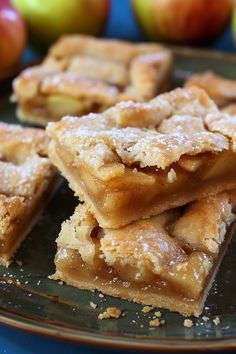 several pieces of apple pie sitting on top of a plate next to some other apples