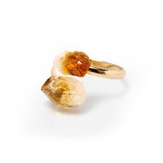 Origin: Brazil Add some brightness to your outfit with this raw citrine ring. Citrine is known as a stone of joy and happiness, which makes it the perfect accessory to help you radiate positive vibes. It's also associated with the sacral and solar plexus chakras, meaning it can help stimulate creativity, passion, and intimacy. Made with a 100% pure, natural, raw citrine crystal and gold-plated copper base, this ring is adjustable to fit any sized finger. Plus, it comes with a premium storage pou Adjustable Citrine Birthstone Ring, Spiritual Citrine Gemstone Rings, Spiritual Open Ring With Natural Stones, Amber Crystal Promise Ring, Adjustable Citrine Gemstone Rings, Adjustable Amber Open Ring Jewelry, Adjustable Orange Jewelry Ring, Spiritual Healing Rings, Adjustable Citrine Ring