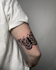 a black and white butterfly tattoo on the arm