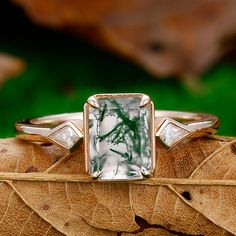 a green and white ring sitting on top of a leaf