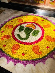 a large flower arrangement on the floor in front of a door with an omesh symbol