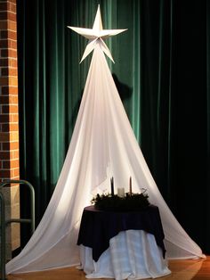 a large white star on top of a table next to a black cloth covered chair