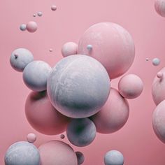 pink and blue bubbles floating in the air on a pink surface with white dots around them