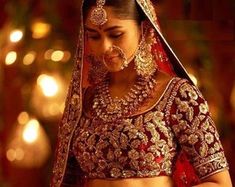 a woman in a red and gold bridal outfit