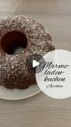 a chocolate bundt cake on a white plate with the words marmel laden - kuchen above it