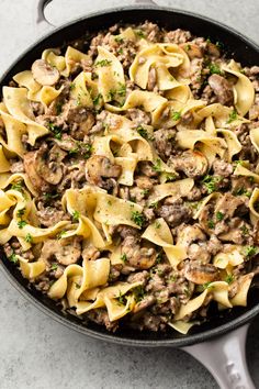 a skillet filled with pasta and mushrooms