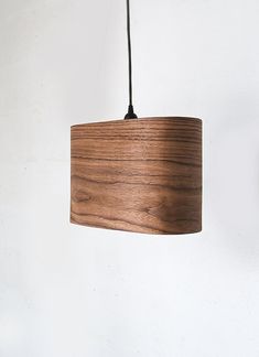 a wooden light fixture hanging from a white wall