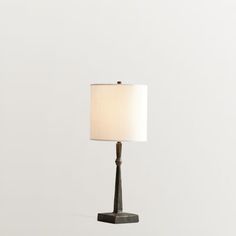 a table lamp with a white shade on it's base and a black metal stand