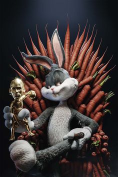 a rabbit sitting on top of a pile of carrots next to a gold statue