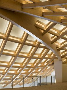 the inside of a large building with wooden beams and lights on it's ceiling