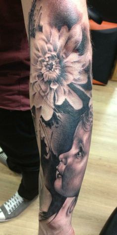 a woman's leg with flowers on it and a man's face in the middle