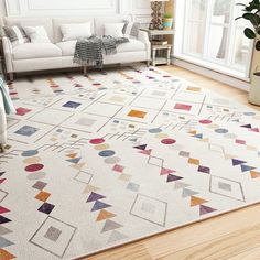 a living room with a white couch and colorful rug