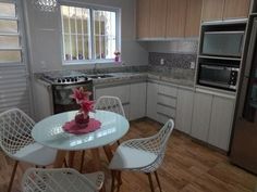 a kitchen with white chairs and a table in the center, next to an oven