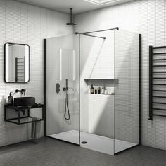 a black and white photo of a bathroom with a shower, sink, mirror and towel rack