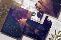 the wedding stationery is laid out on top of each other, with purple and gold accents