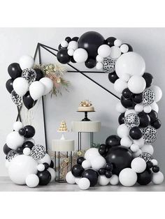 black and white balloons are arranged in the shape of an arch